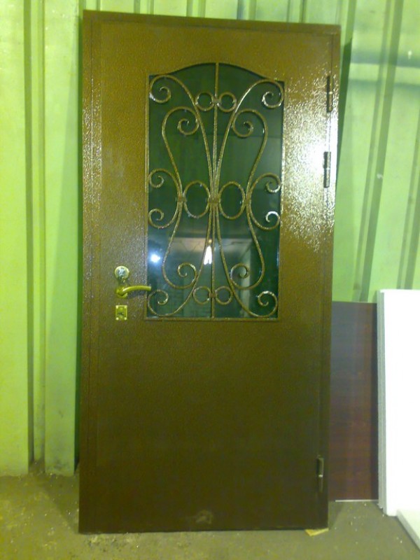 Стальная дверь с коваными завитками и большим тонированным стеклопакетом